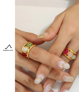Detail of vintage stainless steel rings set with colorful oval stones on a hand