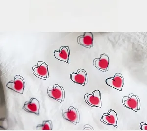 Detail of 5D embossed nail stickers featuring red and black heart designs on a clear sheet