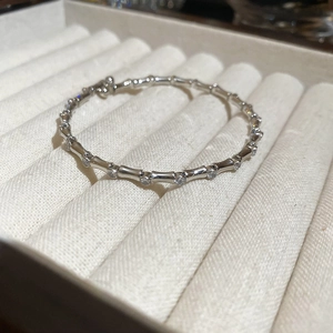 Detail of silver bamboo style bracelet with zircon accents on soft velvet tray