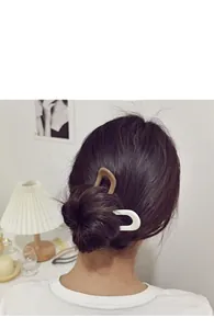 Detail of minimalist U-shaped hair stick pins in beige and white matte resin finish