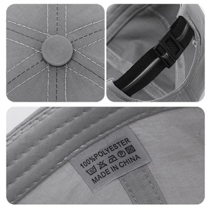 Dettaglio del cappellino sportivo grigio che mostra cuciture, bottone e fibbia regolabile