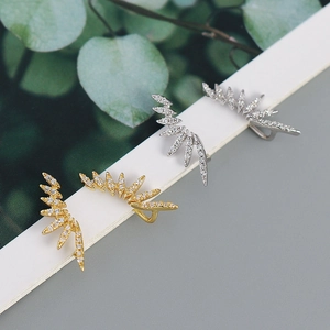 Detailed view of feather-shaped ear cuffs with micro-pave cubic zirconia on white card