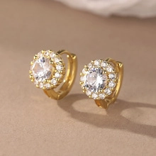 Macro shot of gold-plated hoop earrings with large round zircon and halo of small crystals