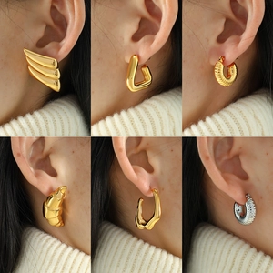 Set of minimalist 18k gold geometric earrings including croissant and triangle styles
