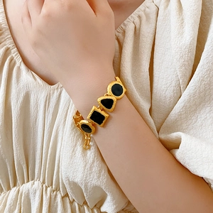 Gold vintage bracelet with black geometric gemstones worn on a model's wrist