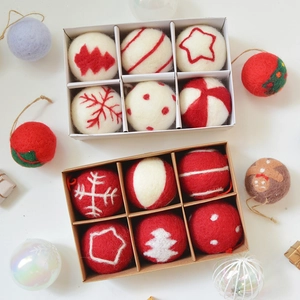 Set of wool felt Christmas tree ornaments with festive snowflake and star patterns in a gift box