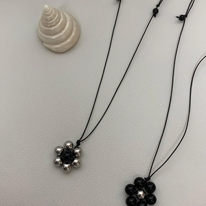 Close-up of black onyx beaded flower pendants with adjustable cord necklaces for women