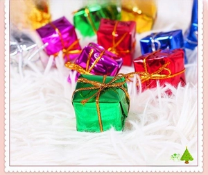 Colorful assorted Christmas tree gift box ornaments with shiny metallic foil and gold ribbons