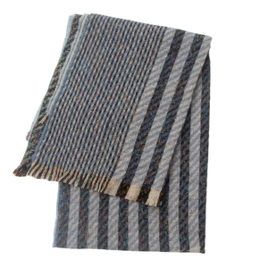 Detail view of blue and grey striped knit scarf with soft fringe on a clean background