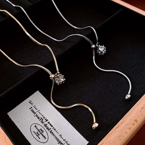 Detail of gold and silver snake chain necklaces with zircon pendants in a jewelry box