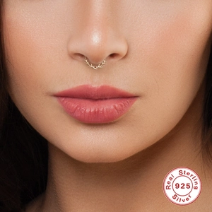 Detail of 925 sterling silver septum nose ring featuring a unique antler design on model
