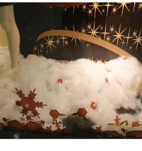 Detail of white artificial snow cotton with festive red and silver ornaments for display
