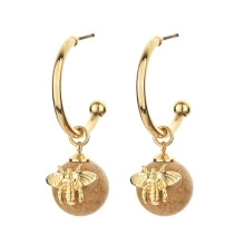 Detail view of gold chain drop earrings with brown resin beads and gold bee charms