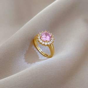 Bague ajustable en or avec cristal rose rond serti sur un fond de soie beige soyeux