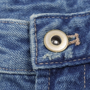 Close-up of metal button and denim texture on American retro wide leg jeans