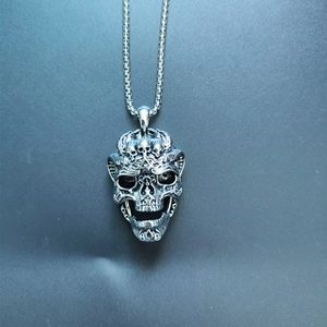 Detailed view of vintage silver skull pendant with intricate gothic dragon scale textures