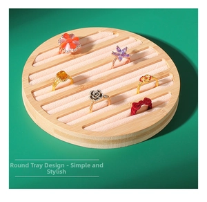 Detail view of round bamboo jewelry tray with five pink velvet slots for rings