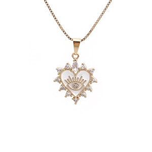 Détail du pendentif cœur doré avec motif œil protecteur blanc et zircons brillants
