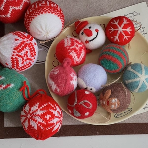 Close-up of knit Christmas tree ornaments featuring snowman and gingerbread man textures