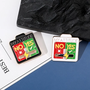 Detailed close-up of sliding enamel pins with black and white MY ATTITUDE selector designs