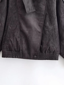 Détail de la veste noire en suédine avec poches à la taille et ourlet côtelé
