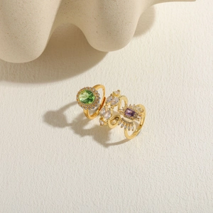 Detailed stack of three gold rings with green, purple, and white zircon gemstones