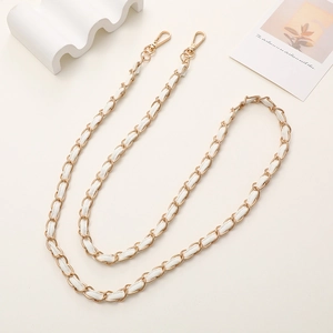 Detail of gold metal and white leather woven chain strap with spring lobster clasps