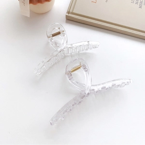 Detailed view of large transparent square hair claws with golden metal springs