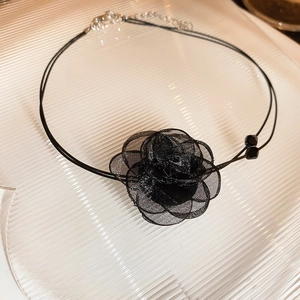 Detail of double-layer black lace choker featuring a delicate mesh flower and small beads