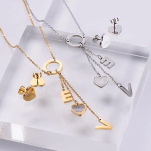 Detail of gold and silver plated jewelry set with heart pendants and shell inlays