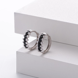Detail of silver S925 huggie earrings with black cubic zirconia and spiked studs