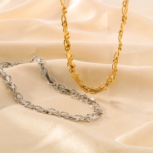 Intertwined woven pendant necklace in 18k gold and silver finish on silk background