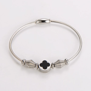 Detail of steel wire rope bracelet with black four-leaf clover and spiral metal beads