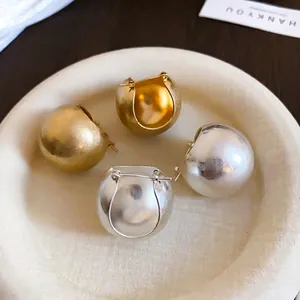 U-shaped hollow basket earrings in gold and silver finish with matte metallic texture