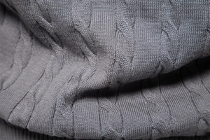 Close-up of grey cable knit texture on a premium men's winter sweater pullover