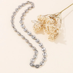 Detailed view of silver oval link pig nose chain necklace with decorative dried flowers