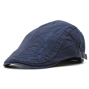 Detail of navy cotton beret hat showing side metal adjustment buckle and embroidery