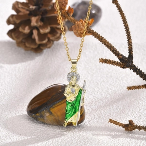 Macro detail of St. Jude religious pendant with green enamel and gold plated chain