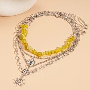 Detail of layered sun and star pendant necklace with yellow stone beads and silver chain