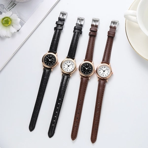Flat lay of minimalist quartz watches with black and brown leather straps in rose gold
