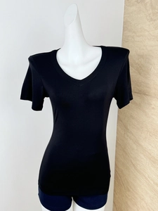 Detail view of black V-neck top with slim fit tailoring and padded shoulder design