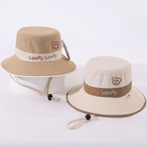 Détail d'un chapeau bob pour enfant avec broderie ours et cordon coupe-vent ajustable