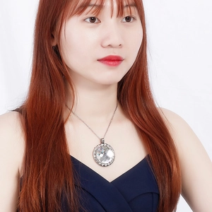 Silver necklace with a round crystal pendant shown on a model for a stylish look