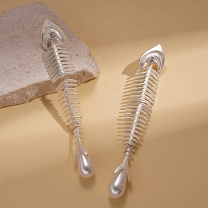 Detail of silver fishbone earrings with sparkling zircons and elegant white pearls