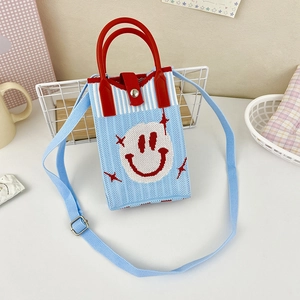 Close-up of light blue knitted phone bag with white smiley face and red stars