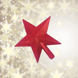 Close-up of a sparkling red five-pointed star tree topper with festive gold bokeh background