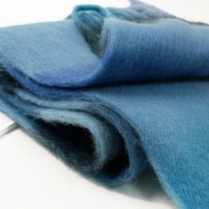 Detail of soft mohair scarf showing thick blue and cyan checkered wool texture