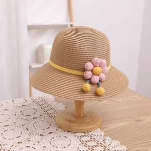 Vue détaillée du chapeau de paille enfant avec fleur rose et perles jaunes décoratives