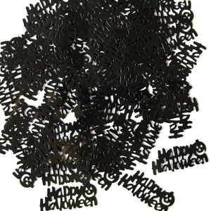 Close-up of black Happy Halloween confetti with pumpkin patterns for party decor