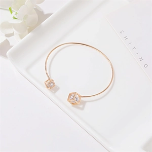 Elegant gold open bangle featuring hollow geometric cubes and sparkling zircon stones